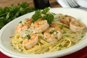 A luscious plate of creamy shrimp scampi with tender shrimp, garlic cream sauce, and parsley, served over pasta with