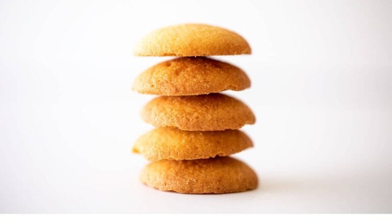 A stack of golden, crispy wafer cookies placed on a white background.